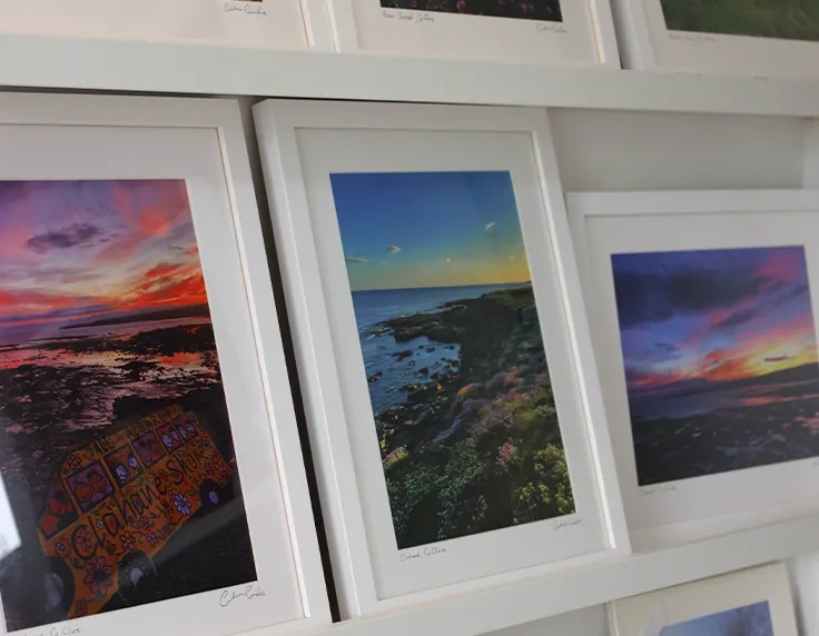 Framed printed photographs leaning against wall