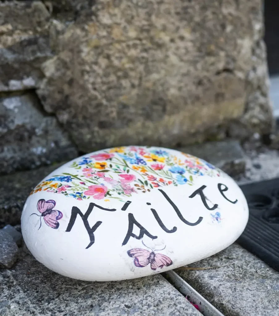 A decorated and painted rock that says Failte