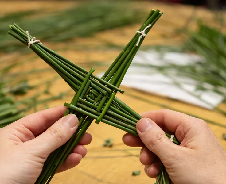 Brigid's cross being made close up of hands