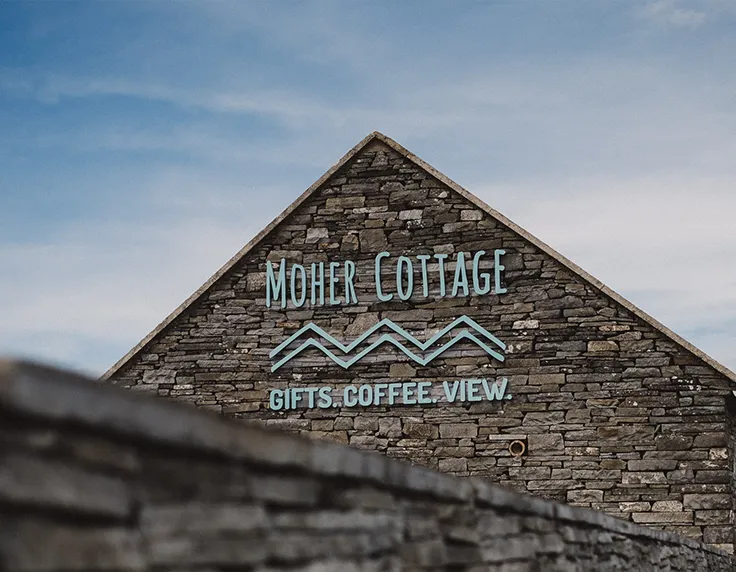 Moher Cottage roof and logo against sky